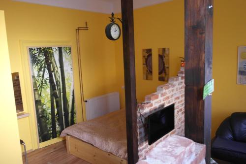 ein Wohnzimmer mit einem Kamin und einer Uhr an der Wand in der Unterkunft Nádasdy Studió Apartment in Szombathely