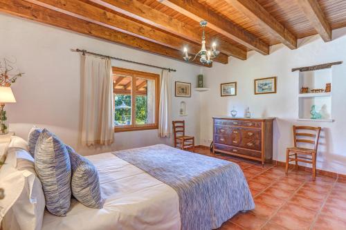 a bedroom with a bed and a wooden ceiling at Can Vaja in Pollença