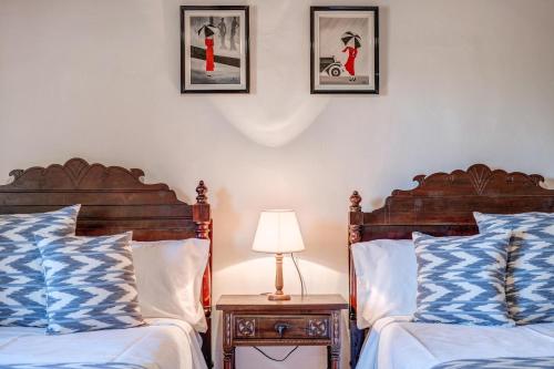 two beds in a bedroom with three pictures on the wall at Can Vaja in Pollença