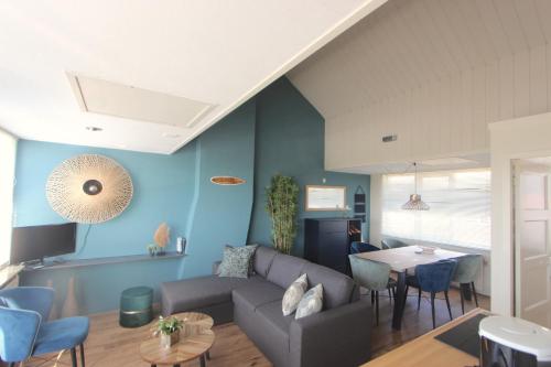 ein Wohnzimmer mit Sofa und Tisch in der Unterkunft Fijne vakantiehuizen 50 mtr van het strand in Egmond aan Zee
