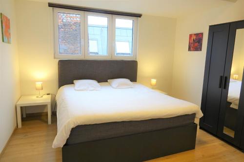 a bedroom with a large bed with two white pillows at The Roof - Rooftop appt in historical center in Antwerp