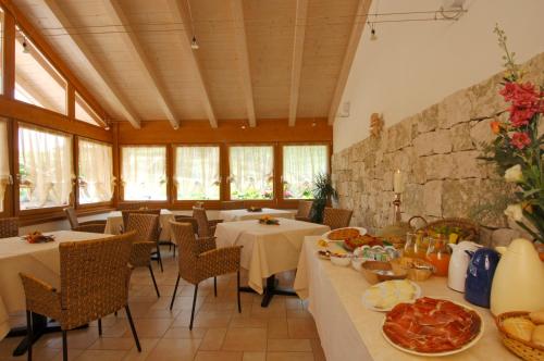 un restaurante con mesas y sillas con comida. en Agriturismo Maso Grener, en Lavis