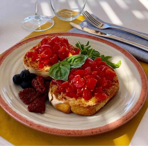 un plato de comida con pan y fruta en una mesa en Borgo Rosso Terra, en Gallipoli