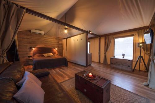 una camera con un letto e un divano in una tenda di Glamping Tents and Mobile Homes Trasorka a Veli Lošinj (Lussingrande)