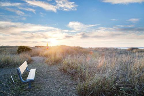 a bench sitting on a path in a field at Sandpiper Condo in Moclips