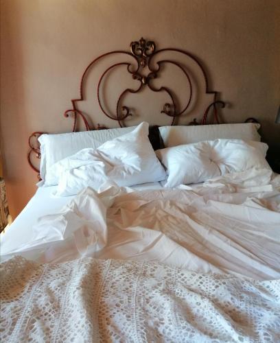 a white bed with white sheets and pillows at Corte di Maggio B&B Country House in Imola