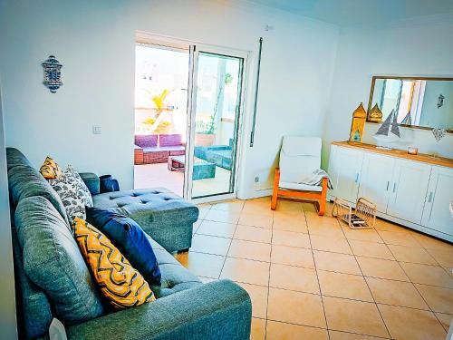 a living room with two blue couches and a table at Cabanas Terraces - Pool and seaview in Tavira