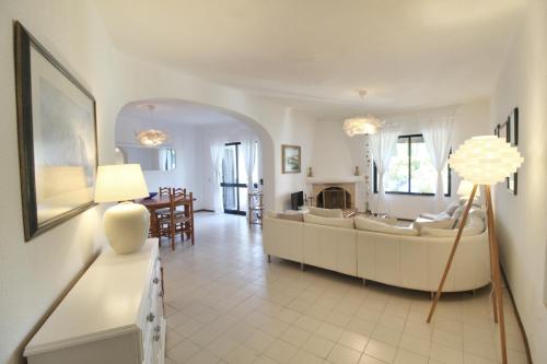ein Wohnzimmer mit einem Sofa und einem Tisch in der Unterkunft Typical Portuguese Beach House just 88m to the beach in Porches