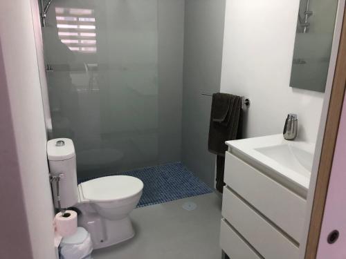 biała łazienka z toaletą i umywalką w obiekcie APARTAMENTO CENTRAL 1 w Corralejo