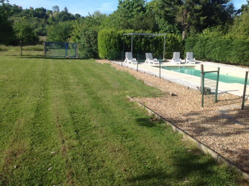 a yard with chairs and a swimming pool at Le Grand Chemin de La Vie in Montcaret