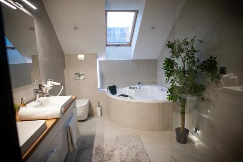 a bathroom with a tub and a sink and a toilet at Villa Warchały in Narty