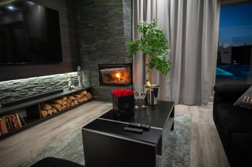 a living room with a fireplace and a black coffee table at Villa Warchały in Narty