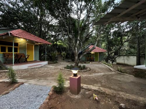 a house with a tree in the middle of a yard at Commune18 Resort Chikmagalur in Chikmagalūr