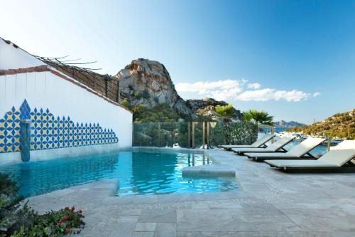 una piscina en un complejo con una montaña en el fondo en Grand Hotel Poltu Quatu, en Porto Cervo