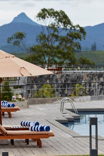 a swimming pool with two lounge chairs and an umbrella at The Argyle Luxury Boutique in Hatton
