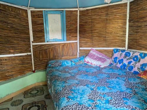 a bedroom with a bed in a room with wooden walls at Al Salam Camp in Luxor