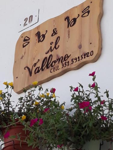 una señal en el lado de un edificio con flores en Il Vallone, en Crispiano