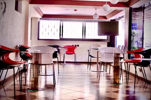 ein Restaurant mit Tischen und Stühlen in einem Zimmer in der Unterkunft ZELLAKA hôtel & café in Khouribga