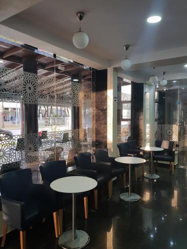 un restaurante con mesas y sillas en una habitación en ZELLAKA hôtel & café, en Khouribga