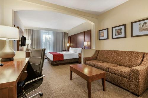 a hotel room with a couch and a bed at Comfort Suites Miami - Kendall in Kendall