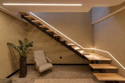 a staircase in a room with a chair and a table at Well Hotel & Spa in Maceira