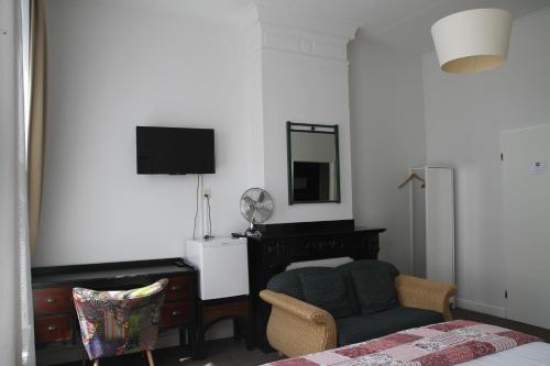 a bedroom with a bed and a chair and a mirror at Hotel Verdi in Amsterdam