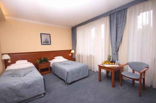 a hotel room with two beds and a table at SPA Hotel Jawor in Jaworze