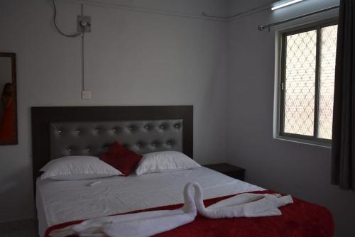 a bedroom with a bed with two white towels on it at Krishna Residency in Port Blair