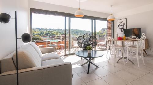 un salon avec un canapé et une table dans l'établissement Le Coquet climatisé avec balcon Terrasse et parking, à Sarlat-la-Canéda