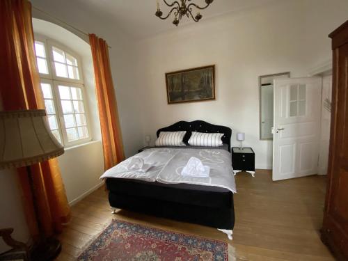 a bedroom with a bed and a chandelier at Schloss Hilbringen in Merzig