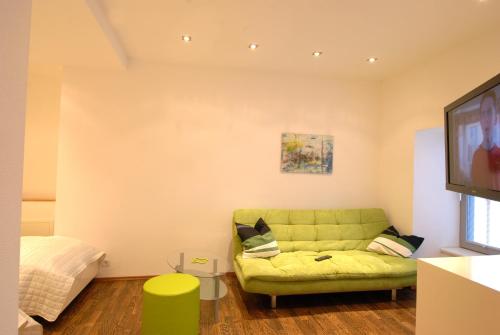 a living room with a green couch and a flat screen tv at Appartement Haberl in Bruck an der Mur