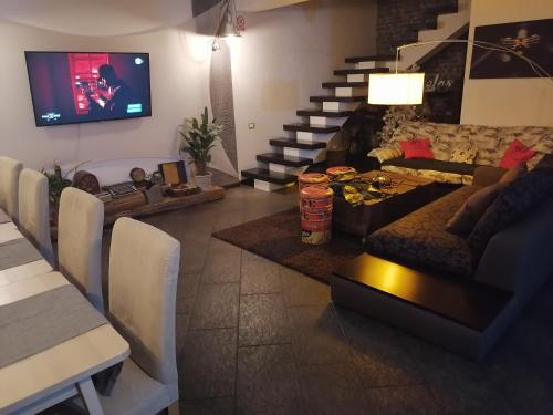 ein Wohnzimmer mit einem Sofa und einem TV in der Unterkunft Relax in Bran