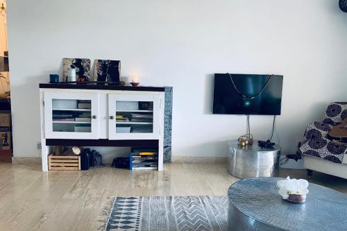 un salon avec une table et une télévision dans l'établissement Sea View Pool Bright And Modern Flat Near Beach, à Antibes