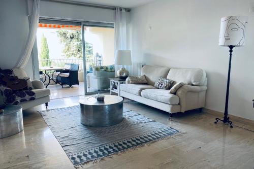 un salon avec un canapé et une table basse dans l'établissement Sea View Pool Bright And Modern Flat Near Beach, à Antibes
