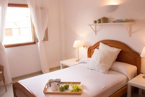 Un dormitorio con una cama con una bandeja de fruta. en Miramar, en Cala Figuera