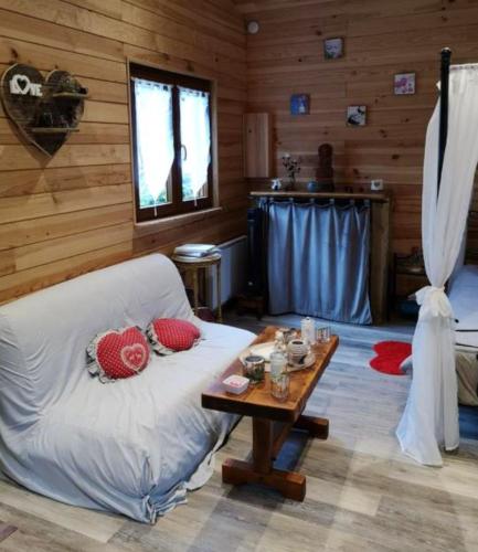 un salon avec un canapé et une table dans l'établissement Chalet chaleureux à Louâtre avec piscine partagée, à Louâtre