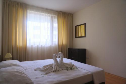 1 dormitorio con 1 cama blanca y ventana en Комплекс Бяла Виста до Плажа - Complex Byala Vista near the beach, en Byala