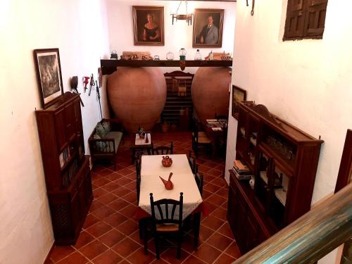 a room with a table and chairs and a large vase at Hotel Rural Posada Los Caballeros in Almagro