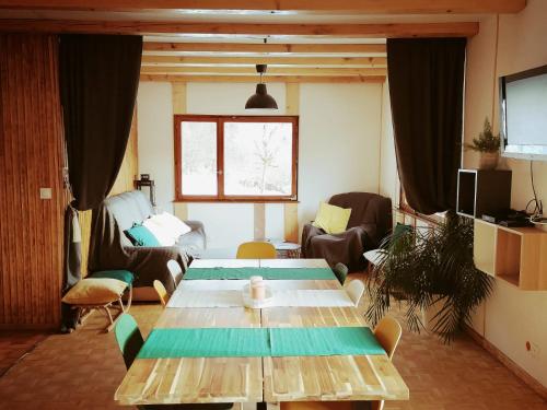 sala de estar con mesa de madera y sillas en La clé des champs, en Colroy-la-Roche