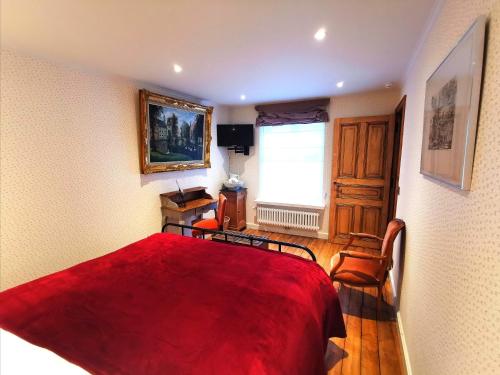a bedroom with a red bed with two chairs and a window at Old Bruges B&B in Bruges
