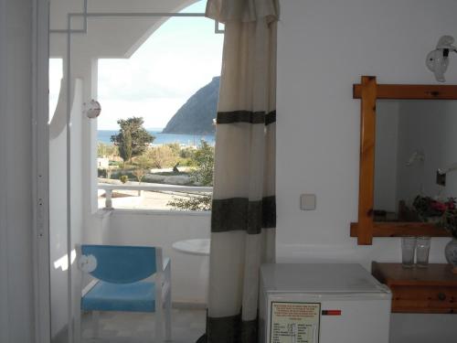 a room with a window with a view of the ocean at Antonis Hotel in Kefalos