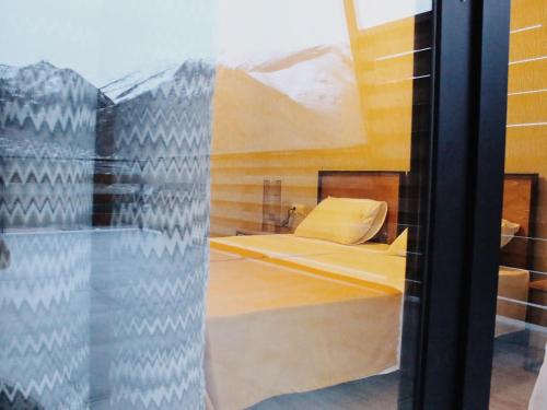 a reflection of a bed in a window at Capra Hotel Kazbegi in Stepantsminda