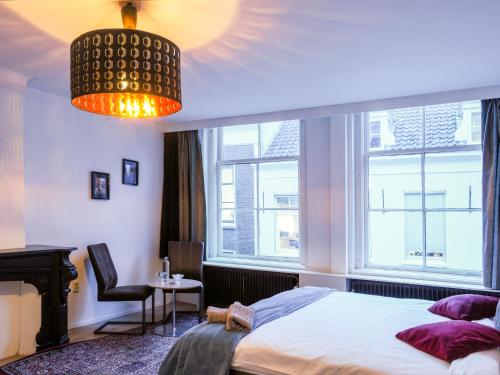a bedroom with a bed and a piano and a chandelier at Zala's B&B in Utrecht