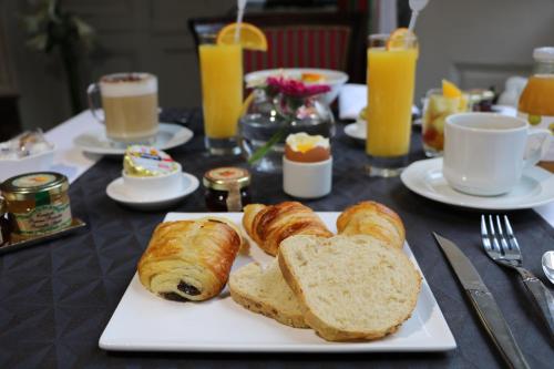 a table with a plate of bread and croissants at Hotel D'haussonville in Nancy