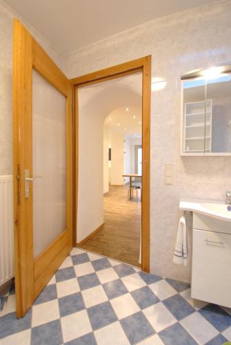 a kitchen with a door and a checkerboard floor at Appartement Haberl in Bruck an der Mur