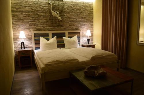 ein Schlafzimmer mit einem Bett und einer Ziegelwand in der Unterkunft Hotel Arte Vida OHG in Spremberg