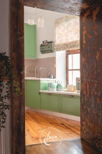 a kitchen with green cabinets and a wooden floor at FLH - Luna Homes in Sibiu