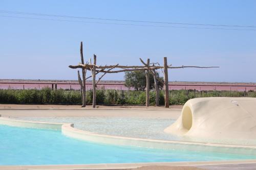 a swimming pool with a slide in the middle at Camping Les Bois Flottés in Salin-de-Giraud