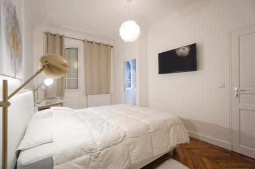 a white bedroom with a bed and a lamp at Modern Duplex Close To The Eiffel Tower in Paris