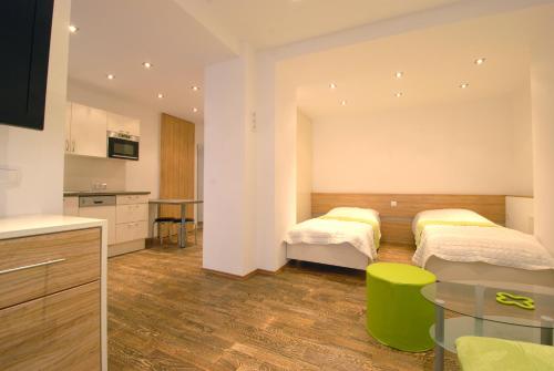 ein Hotelzimmer mit 2 Betten und einer Küche in der Unterkunft Appartement Haberl in Bruck an der Mur